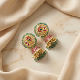 Jadau kundan peacock jhumkas with pearl and natural strawberry beads drop